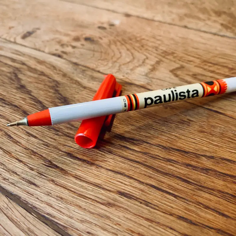 Penna o pennarello con etichetta ’paulista’ e tappo rosso.