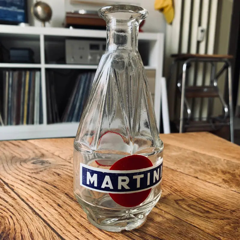 Bottiglia di Martini in vetro con un caratteristico design a coste e logo blu e rosso.