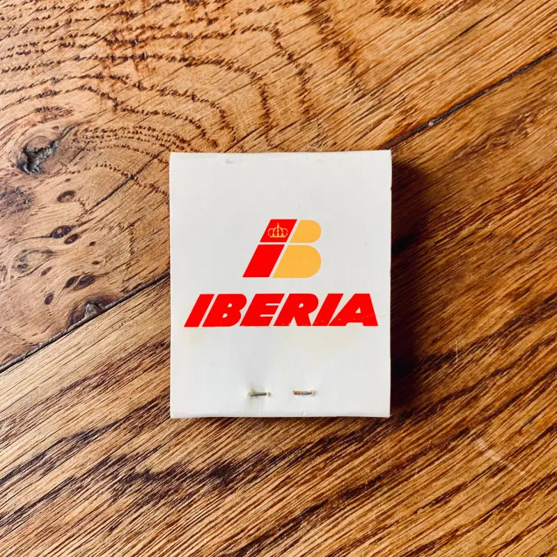 Libro di fiammiferi con il logo della compagnia aerea Iberia in rosso e giallo su sfondo bianco.