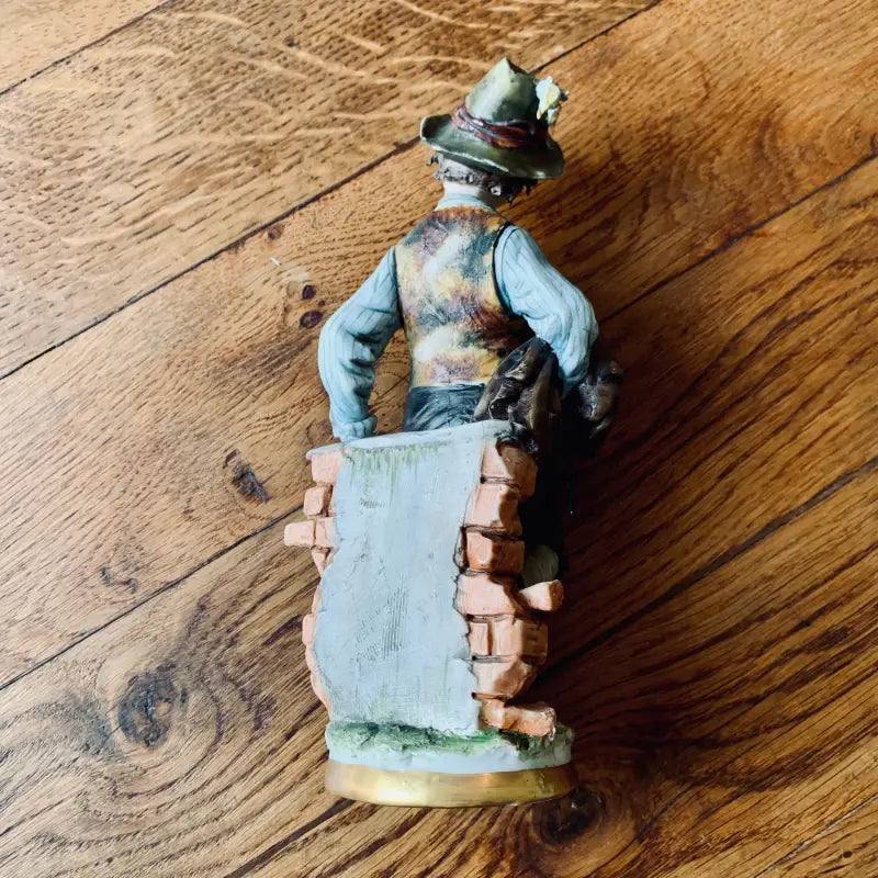 Statuetta in ceramica di un uomo in abiti tradizionali bavaresi o alpini.