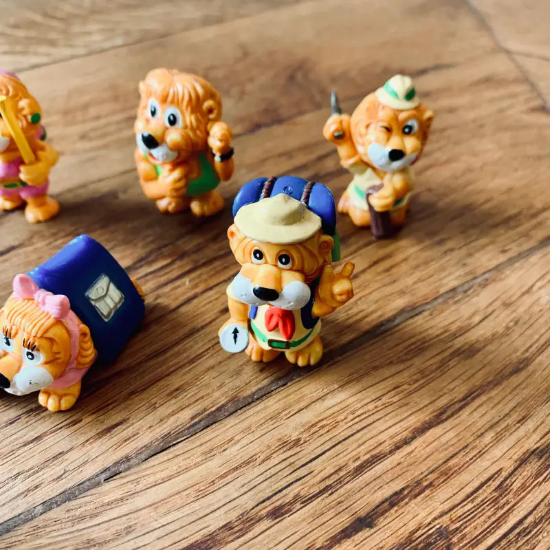 Collezione di figurine di leoni colorati dei cartoni animati con vari abiti e accessori.