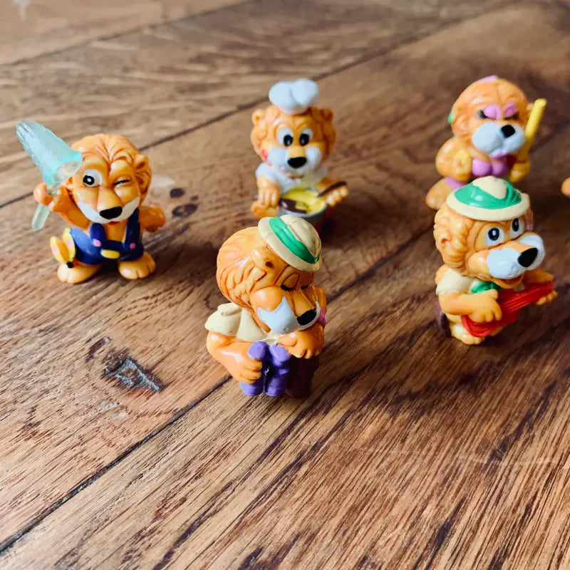 Collezione di statuette di animali in stile cartone animato, per lo più cani o volpi in abiti e pose colorate.