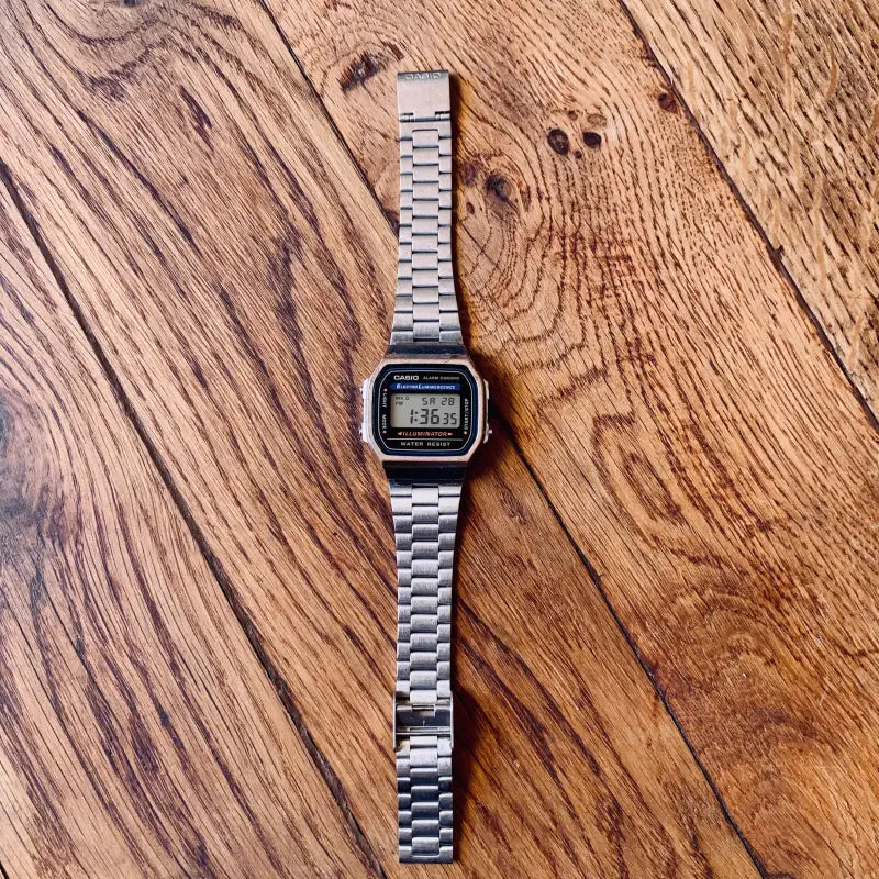 Classico orologio da polso digitale con cinturino in metallo argentato e display quadrato.