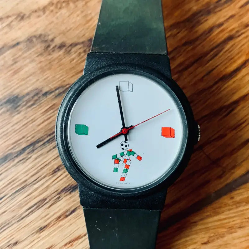 Orologio da polso con un quadrante dal design unico, caratterizzato da una figura di robot colorata e da indici geometrici.