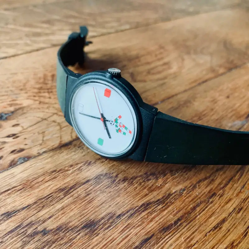 Orologio da polso dal design colorato e minimalista con cinturino verde scuro.