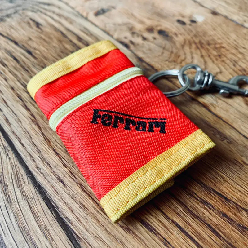 Portachiavi in tessuto rosso e giallo a marchio Ferrari.