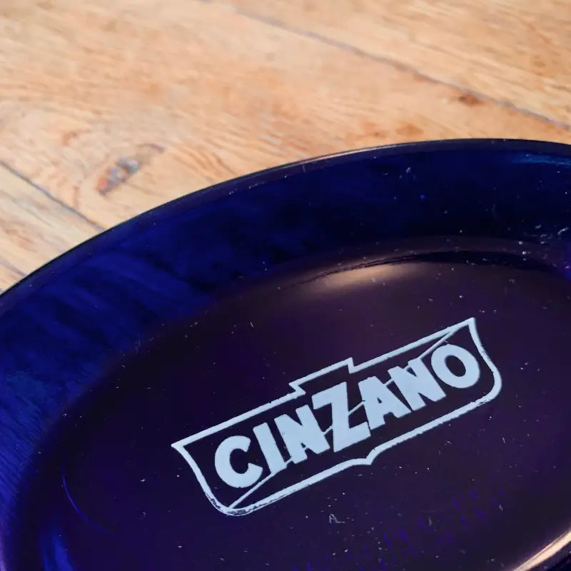 Posacenere in vetro blu cobalto con logo ’CINZANO’.