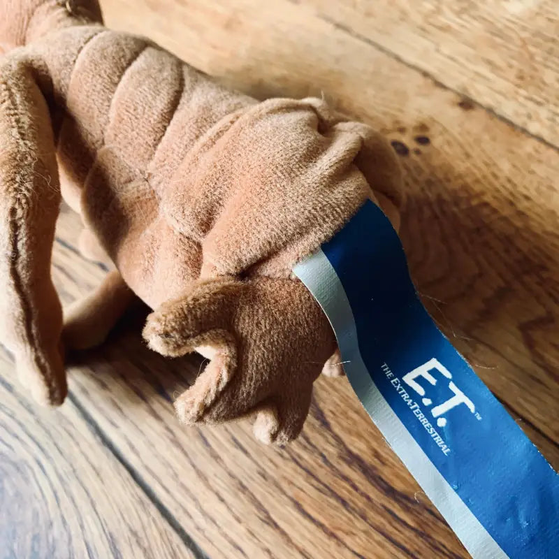 Animale di peluche con etichetta blu con la scritta ’E.T.’.