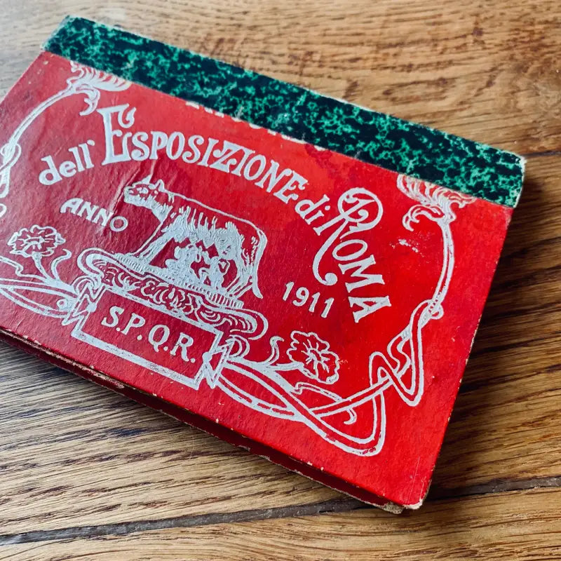 Libro o quaderno italiano rosso d’epoca con testo e illustrazioni ornamentali in copertina.