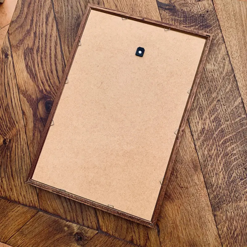 Scatola o confezione di cartone con un adesivo blu su una superficie di legno.