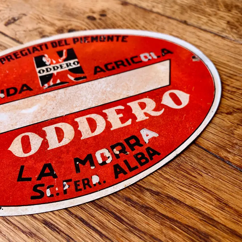 Adesivo o etichetta ovale rossa con la scritta ’ODDERO’ in evidenza, probabilmente per una bottiglia di vino.