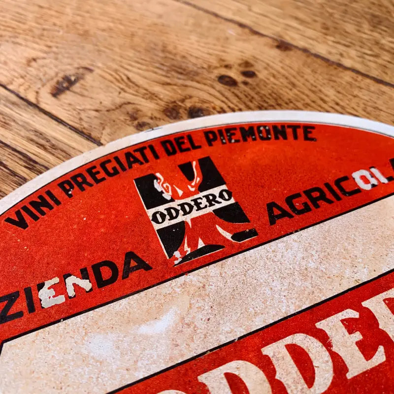 Etichetta o adesivo circolare di colore rosso e bianco con testo in italiano e logo.