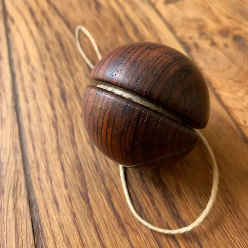 Yo-yo in legno con cordoncino chiaro.