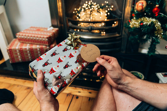 Regalo di Natale incartato accanto a un orologio