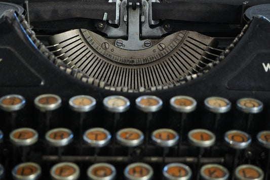 Macchina da scrivere vintage in primo piano su sfondo neutro