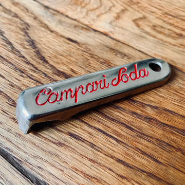 Apribottiglie in metallo in stile vintage con incisione ’Campari Soda’ in caratteri rossi.