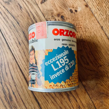 Lattina in metallo di Orzoro, surrogato del caffè, dall’aspetto vintage, su una superficie in legno.