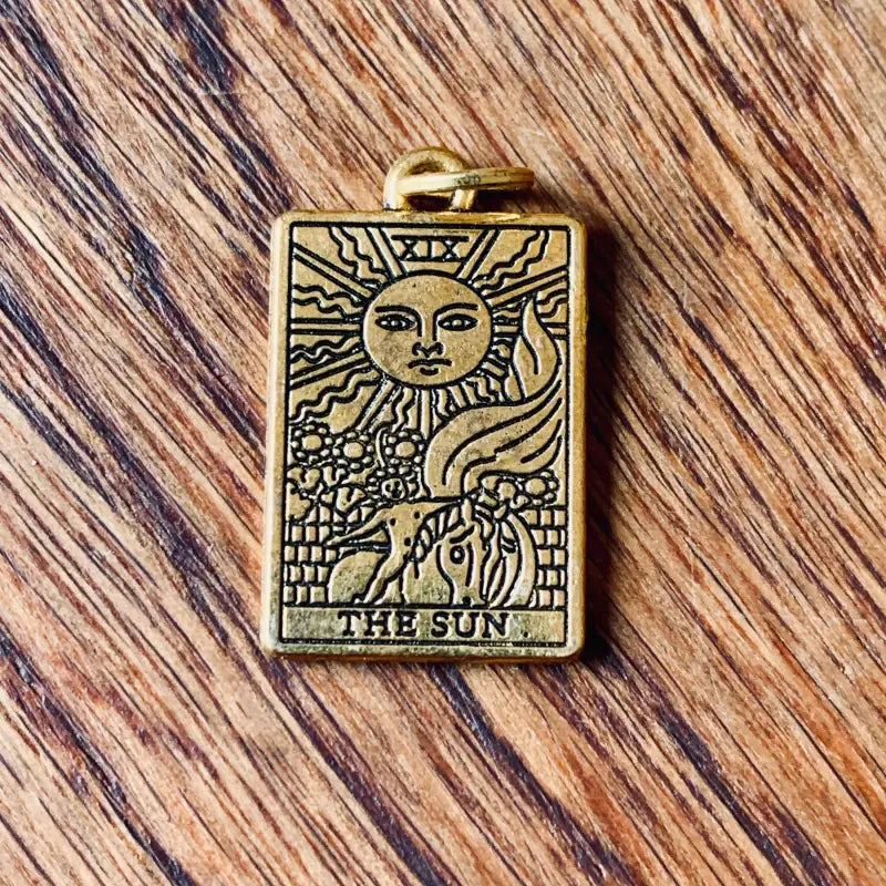 Ciondolo per tarocchi color bronzo raffigurante ’Il Sole’ con immagini celesti e naturali.