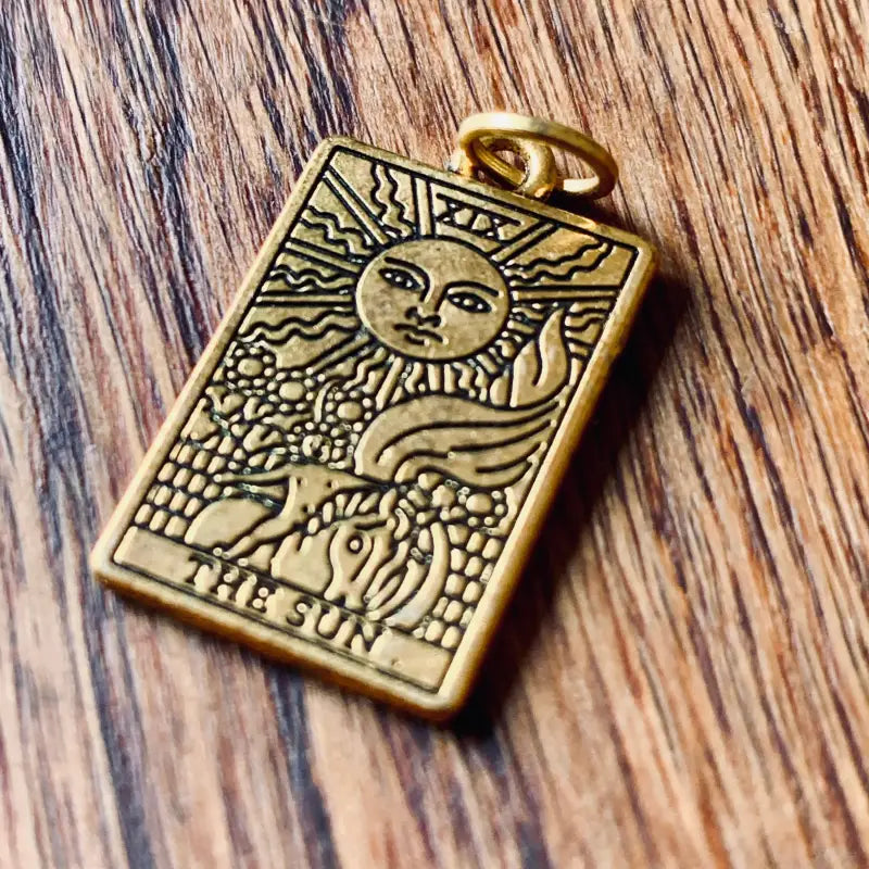 Ciondolo per tarocchi color oro raffigurante ’Il Sole’ con immagini celesti e naturali.