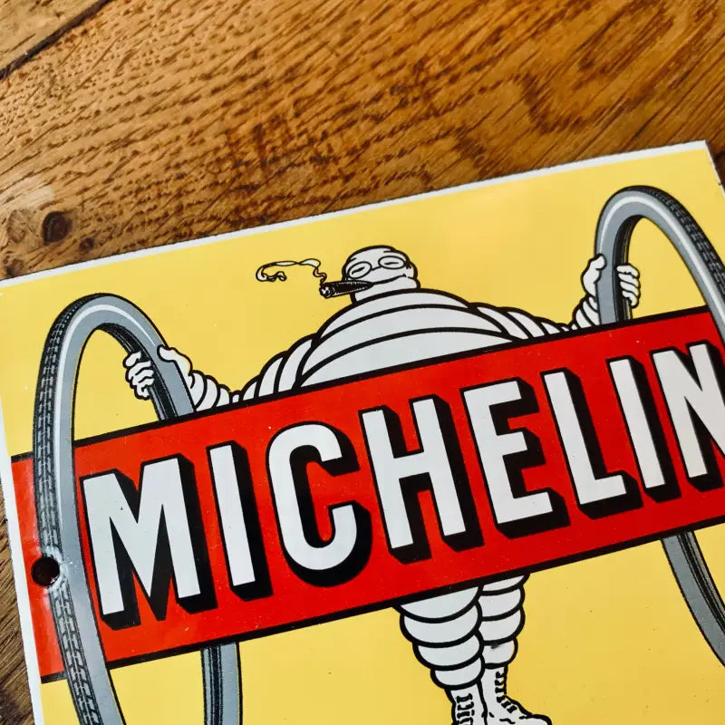 Logo Michelin con l’iconica mascotte di Bibendum su sfondo giallo.