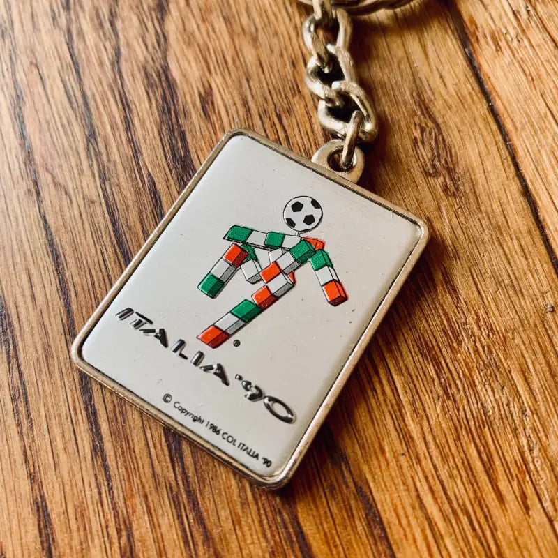 Portachiavi con il logo dei Mondiali di calcio Italia ’90 su una targhetta rettangolare in metallo.