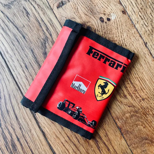 Portafoglio rosso Ferrari con grafica Marlboro e auto da corsa.