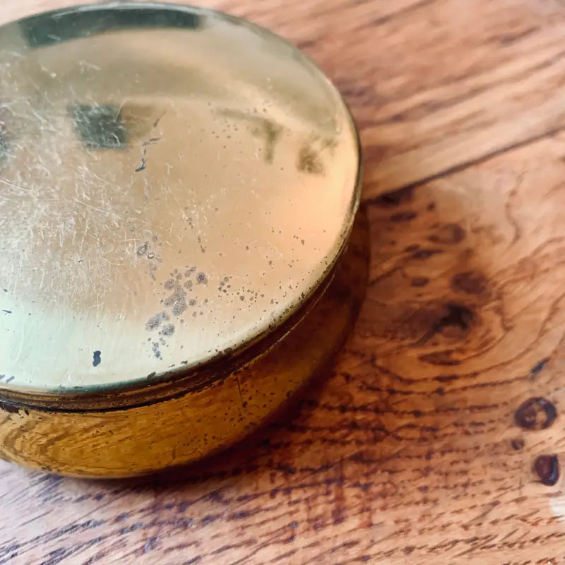 Bicchiere di birra con testa schiumosa su una superficie di legno.