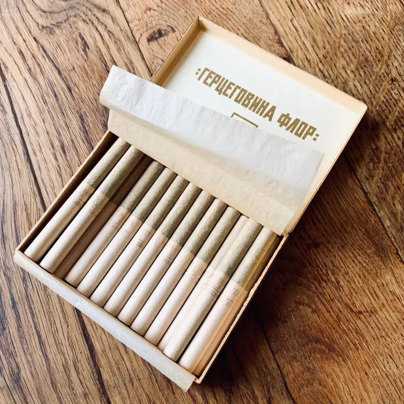 Scatola di legno contenente oggetti cilindrici sottili, probabilmente matite o pastelli.