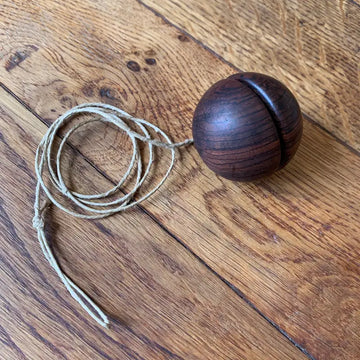 Palla di legno con una scanalatura lungo la circonferenza, accompagnata da una corda.